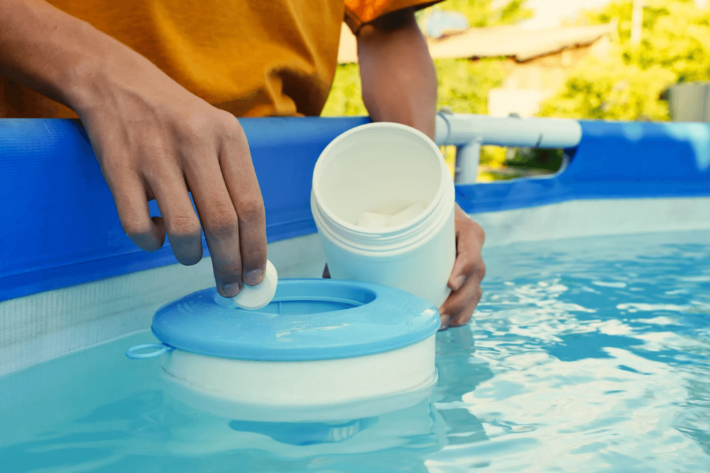 Una persona poniendo cloro en una piscina.