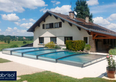 Una casa con una piscina cubierta con la cubierta de piscina tapia telescópica