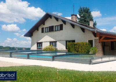 Una casa con una piscina cubierta con una tapia telescópica